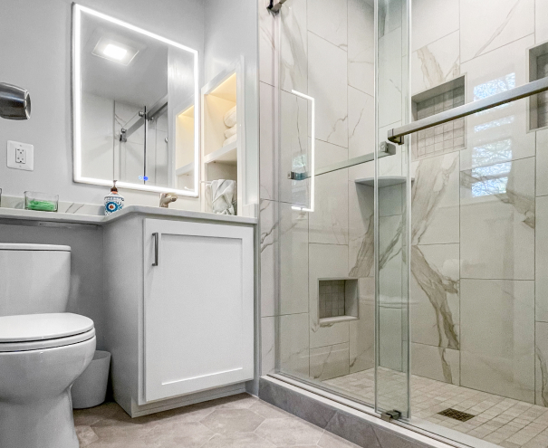 newly remodeled bathroom with vanity mirror and glass door shower