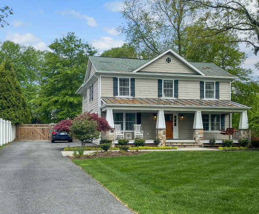 two story home with a porch, yard, and long driveway